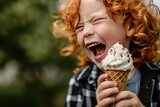 a young boy with red hair is eating an ice cream cone with his mouth open