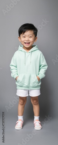 A toddler model wearing a blank solid color hoodie in a studio photoshoot, perfect for mockups or designing custom shirts as templates