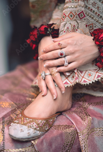 bride wearimg engagement ring and henna hands with red roses photo