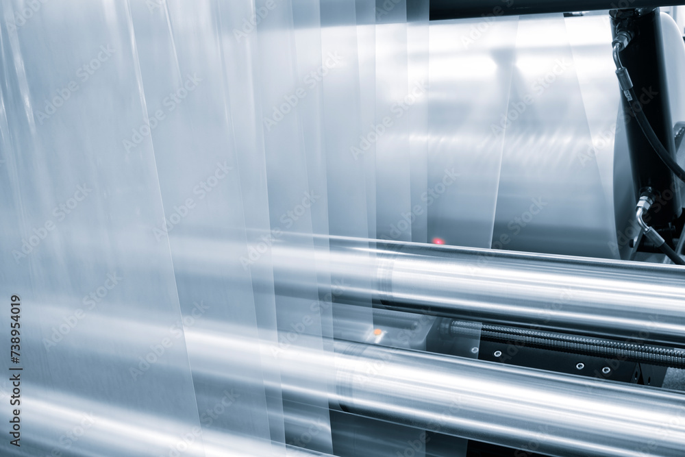 Automatic polyethylene plastic bag production machine with lighting effect. Close-up of the roller of the plastic bag production machine in the light blue scene. product packaging concept Automatic polyethylene plastic bag production machine with lighting effect. Close-up of the roller of the plastic bag production machine in the light blue scene. product packaging concept