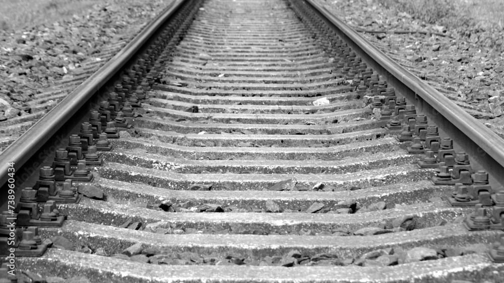 Track, two rails supporting and guiding the wheels of rail vehicles, placed on sleepers in a special concrete slab, at a specific distance from each other, serving as a railway. Black and white