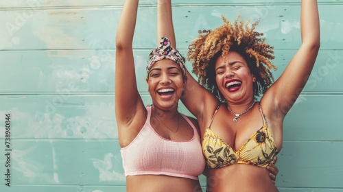 Two joyful showgirls embrace the sunshine, baring their confident smiles and toned abs in matching swimwear tops against a vibrant outdoor wall photo