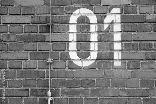 Die Ziffern Null und Eins auf einer Backsteinmauer im Sommer bei Sonnenschein in der Klassikstadt im Stadtteil Fechenheim in Frankfurt am Main in Hessen in neorealistischem Schwarzweiß