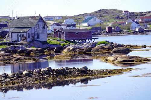 Fogo Island fishing village with reflection of buildings in the water on a summer day photo