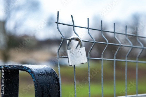 Kłódka zakochanych zapięta na metalowym ogrodzeniu