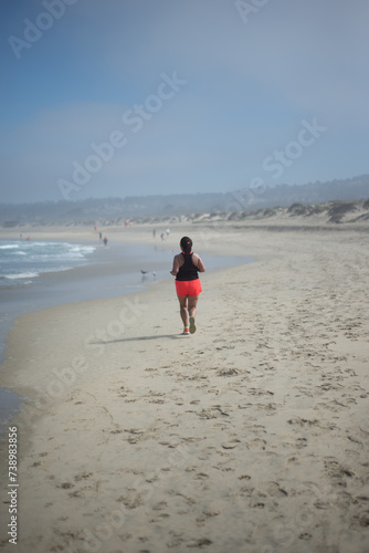 a middle age woman running on the sand of El Tabo beach, Valparaiso, Chile