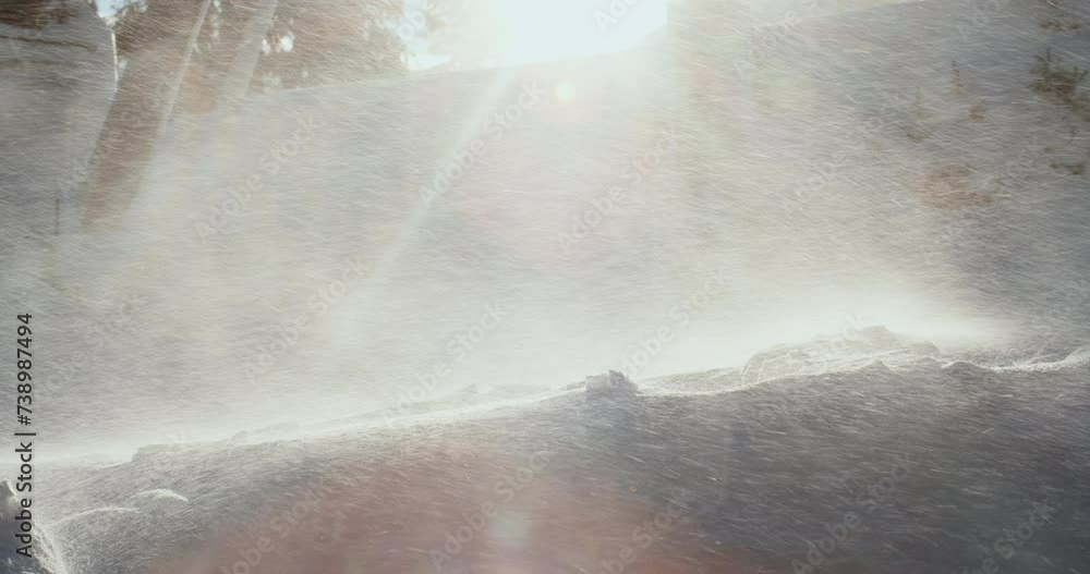 A strong wind whirls the snow into the air in the rays of sunlight A strong wind whirls the snow into the air in the rays of sunlight