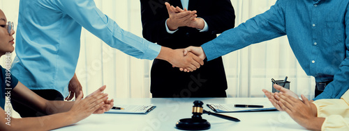 Fotografie Lawyer acting as legal mediator successfully broke a compromise and seal with handshake between two parties to resolve business dispute through negotiation at law firm office