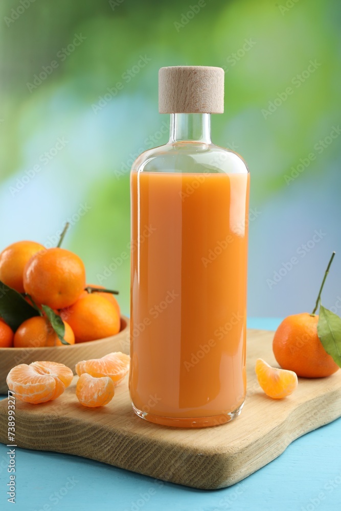 Delicious tangerine liqueur and fresh fruits on light blue wooden table Delicious tangerine liqueur and fresh fruits on light blue wooden table