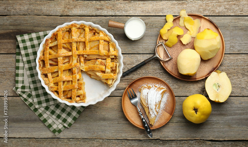 Photos Tasty homemade quince pie, ingredients, peeler and fork on wooden table, flat la
