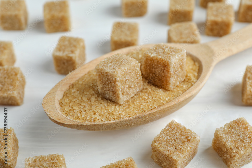 Brown sugar cubes in spoon on white wooden table, closeup Brown sugar cubes in spoon on white wooden table, closeup