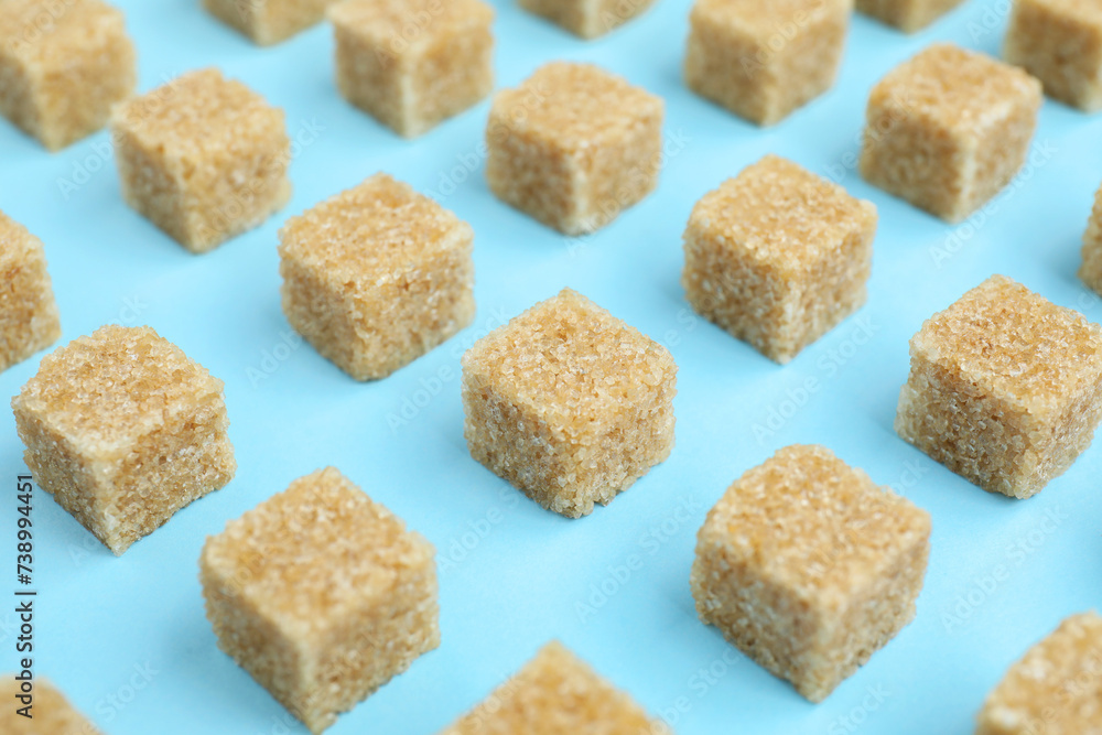 Brown sugar cubes on light blue background, closeup Brown sugar cubes on light blue background, closeup