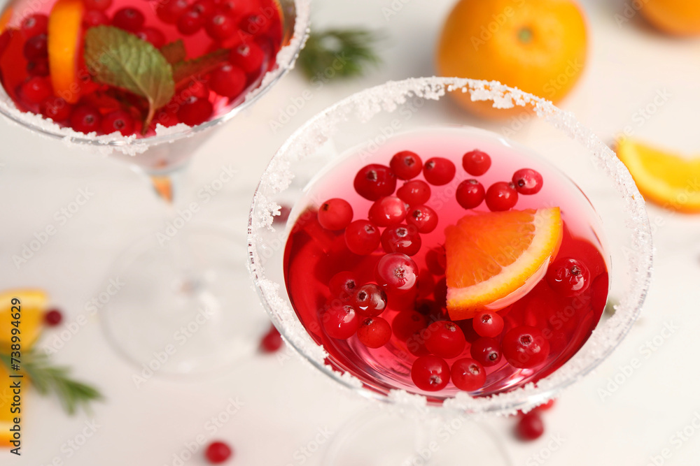 Tasty cranberry cocktail in glasses on white table, above view Tasty cranberry cocktail in glasses on white table, above view