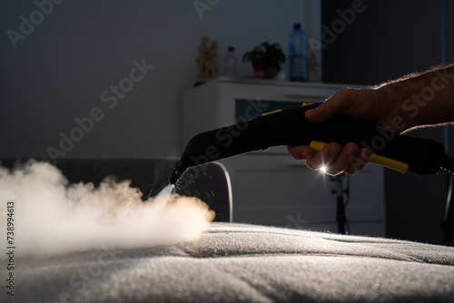 cleaning a gray sofa with steam