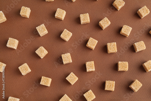 Brown sugar cubes on color background, top view