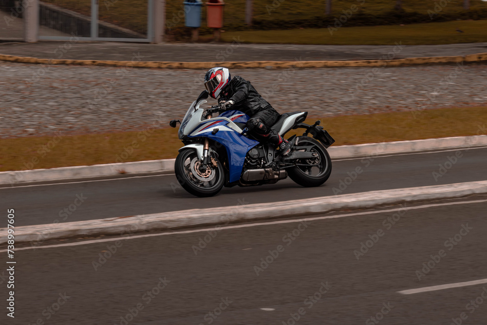 moto esportiva azul fazendo uma curva 