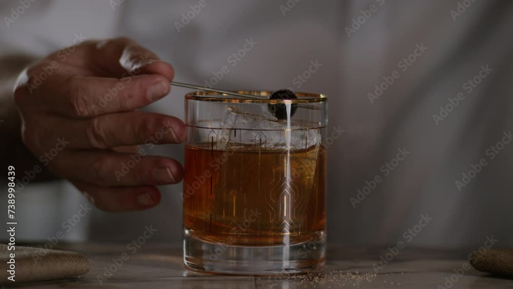 Bartender places a cherry on top of an old fashioned Bartender places a cherry on top of an old fashioned