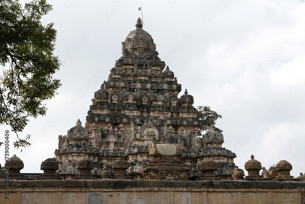 Tower of ancient Kanchi Kailasanathar temple in Kanchipuram, Tamilnadu. Historic Tall Hindu Temple Gopuram against cloudy sky background.
