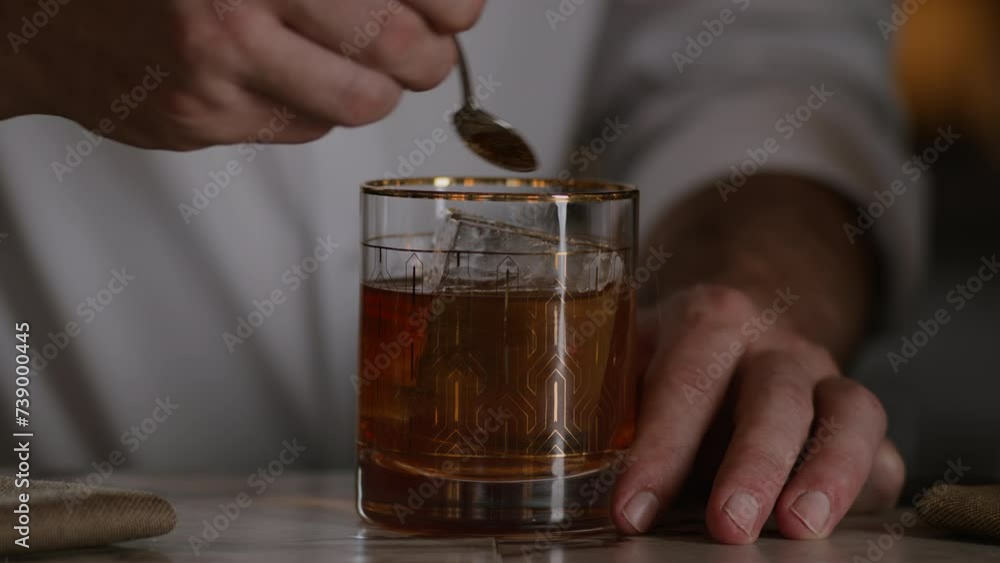 Bartender garnishes an old fashioned with gold sugar Bartender garnishes an old fashioned with gold sugar