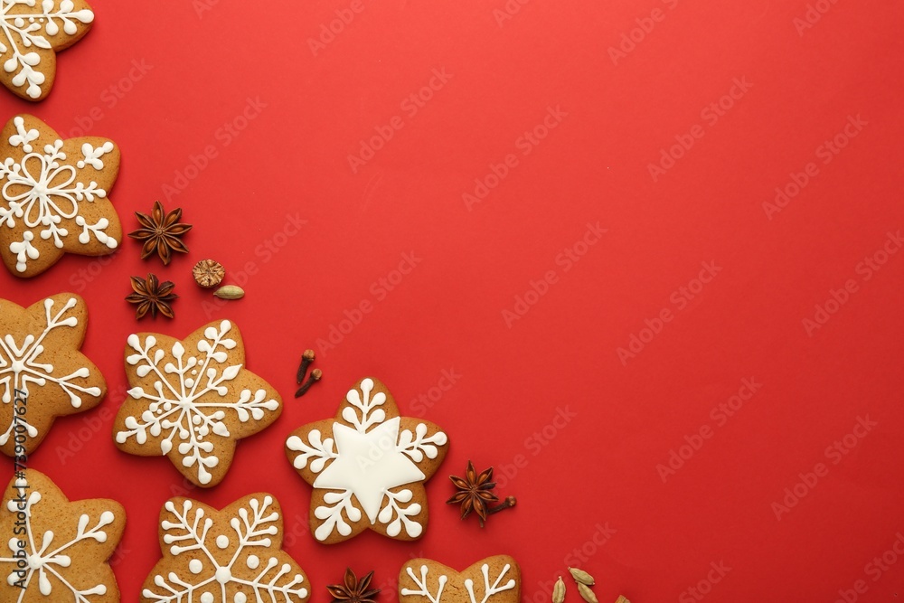 Tasty star shaped Christmas cookies with icing and spices on red background, flat lay. Space for text Tasty star shaped Christmas cookies with icing and spices on red background, flat lay. Space for text