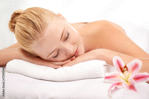 Relax, sleep and woman at spa with flower for luxury holistic treatment, facial health and professional massage therapy. Self care, peace and refresh for girl on bed in natural rest for body wellness