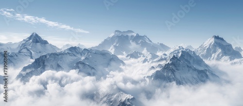 Majestic Snow-Capped Mountains, Towering Peaks Shrouded in Clouds, Evoking a Sense of Grandeur and Serenity.
