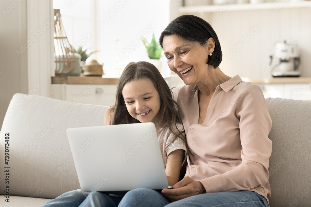 Φωτογραφία Happy mature grandmother and little cute granddaughter spend time together on in
