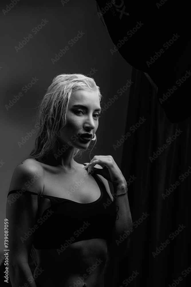 Fototapeta premium Portrait of a young girl with blond hair in a dressing gown in a low key.
