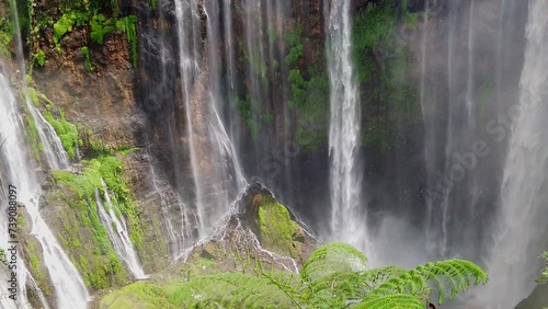 Slow motion of Tumpak Sewu, also known as Coban Sewu, a tiered waterfall that is located in East Java, Indonesia. The Glidik River, which flows down Semeru is the primary source of the waterfall photo