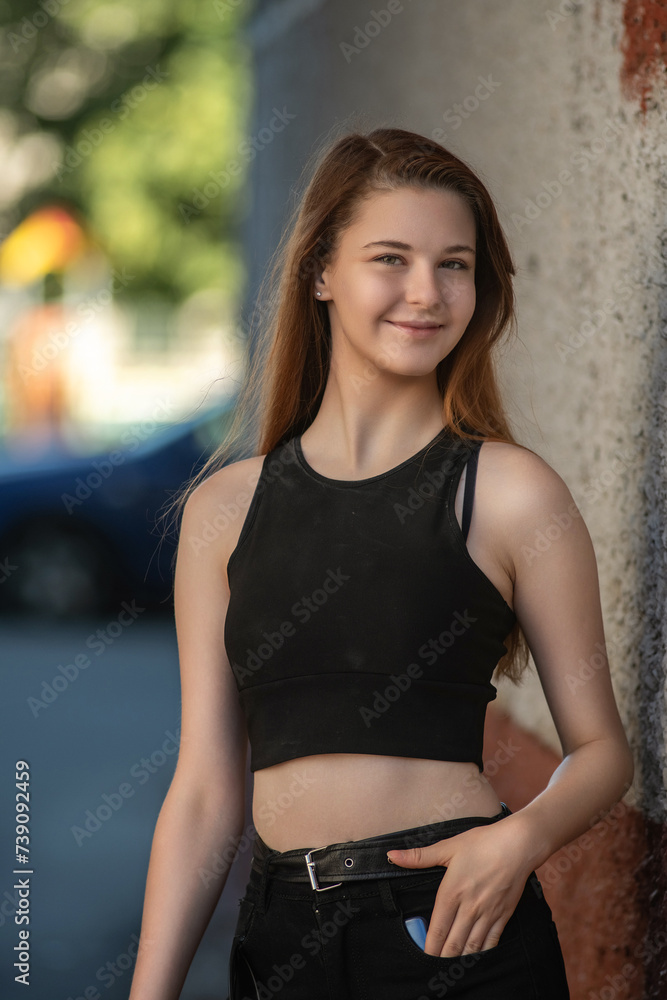 Portrait of a young beautiful red-haired girl on a summer morning in an urban environment. Portrait of a young beautiful red-haired girl on a summer morning in an urban environment.