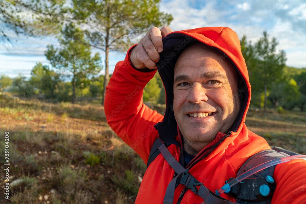 hooded male hiker takes a selfie outdoors hooded male hiker takes a selfie outdoors