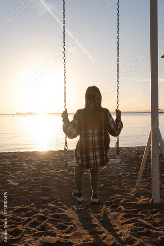 beautiful young woman on the swing on the sky background