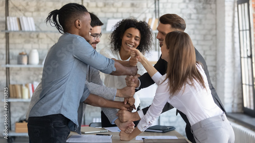 Group of company employees having fun in team building meeting. Smiling business coach engaging office workers in ice breaker activities. Professional team leader teaching workers to be team players photo