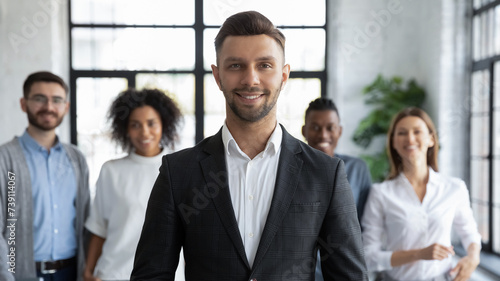 Quadro su tela Happy head of department with reliable, supporting team of professionals in modern office, looking at camera and smiling