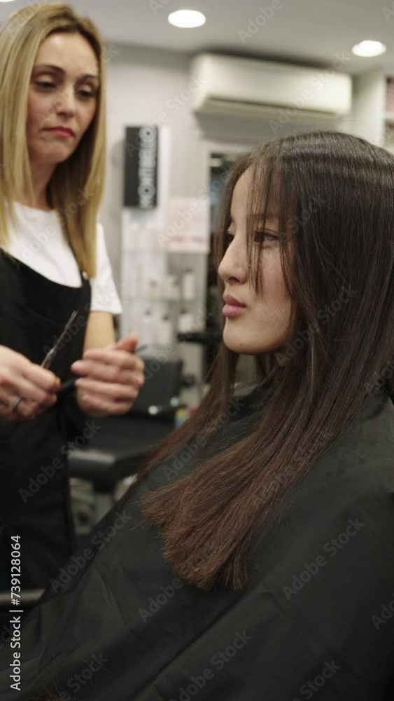 Hairdresser cutting the long hair of a customer Hairdresser cutting the long hair of a customer