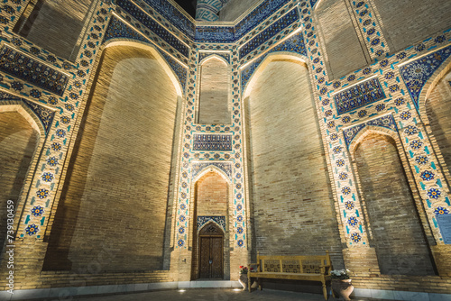 Facade of the Gur Emir mausoleum with mosaics and brick walls at night with illumination in the ancient city of Samarkand in Uzbekistan, oriental architecture in the evening photo