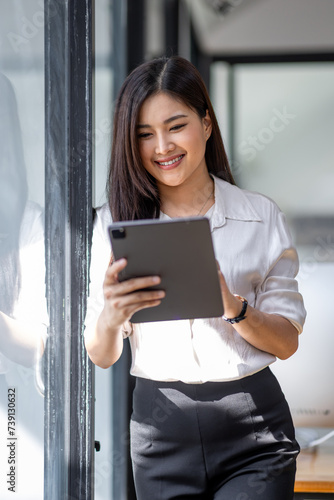 Free Download Young asian busy professional business woman executive, female company worker or manager holding digital tablet technology device working standing in modern corporate office. - GFXLoad