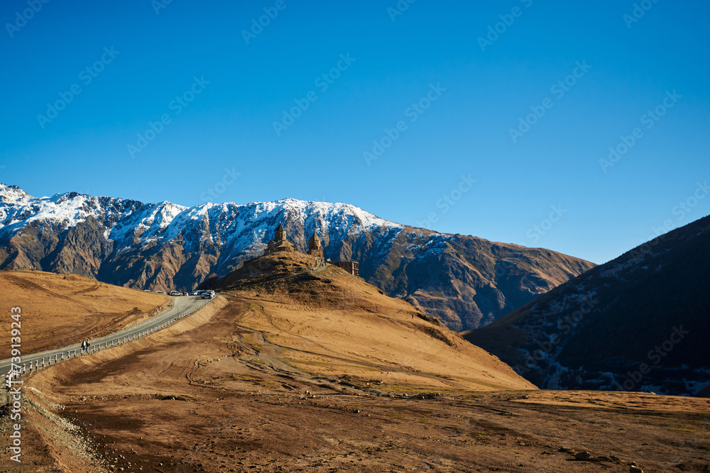 Snow-crowned mountains appearing like giants against the backdrop of a pure blue sky.