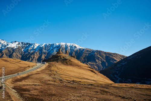 Snow-crowned mountains appearing like giants against the backdrop of a pure blue sky.