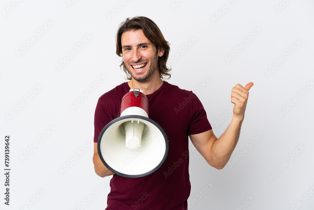 Young handsome man isolated on white background shouting through a megaphone and pointing side Young handsome man isolated on white background shouting through a megaphone and pointing side