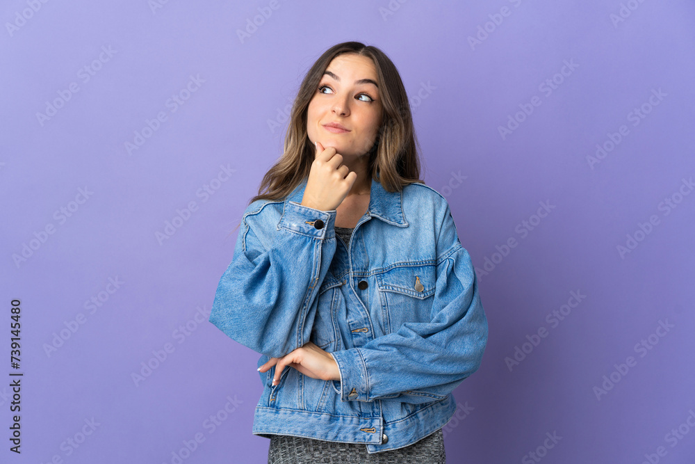 Young Romanian woman isolated on purple background thinking an idea while looking up Young Romanian woman isolated on purple background thinking an idea while looking up