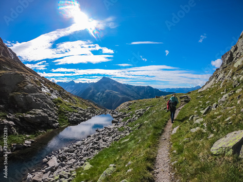 Hiker woman crossing a small river in High Tauern National Park, Carinthia, Austria. Idyllic hiking trail from Hannoverhaus to Hagener cottage in Austrian Alps. Hike paradise Mallnitz. Wanderlust photo