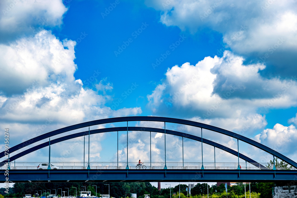 Fototapeta premium Bridge stretches over river under blue sky