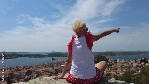 Woman looking the St. John's Fort from the Barone Fortress looking at the cityscape of Sibenik. Skyline with St. Michael castle. Sibenik historic city of Croatia in Dalmatia. photo