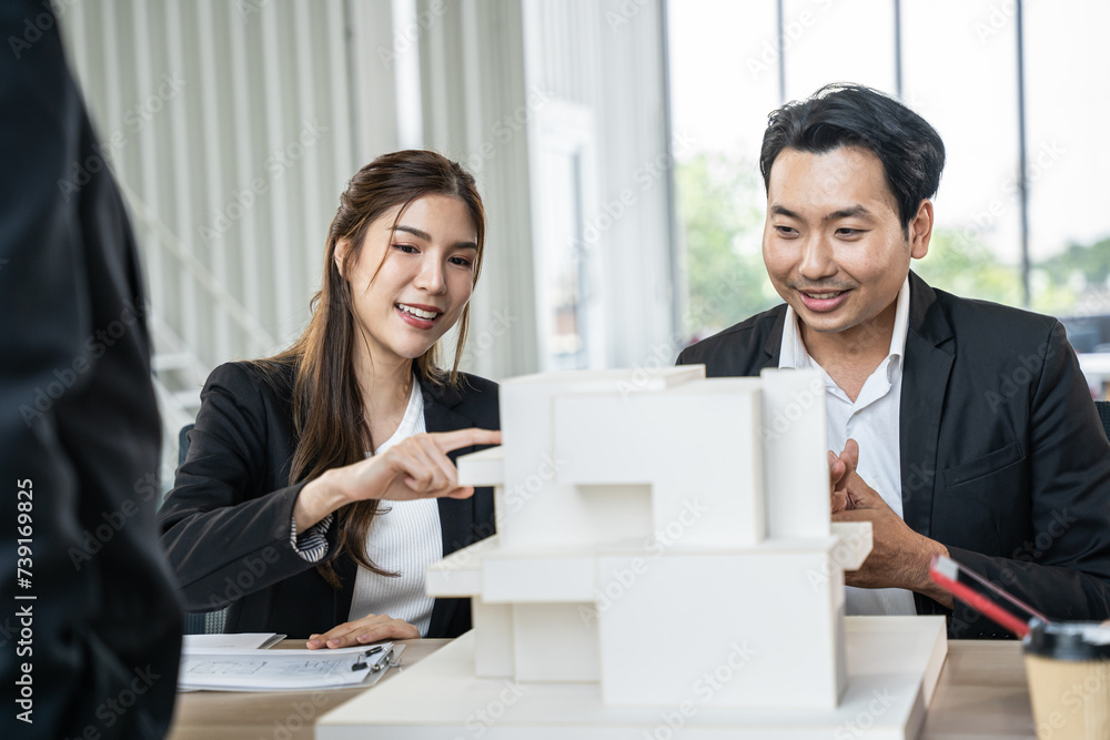 Asian businessman talking with team in meeting room. They dissing about building model and design together. Asian businessman talking with team in meeting room. They dissing about building model and design together.