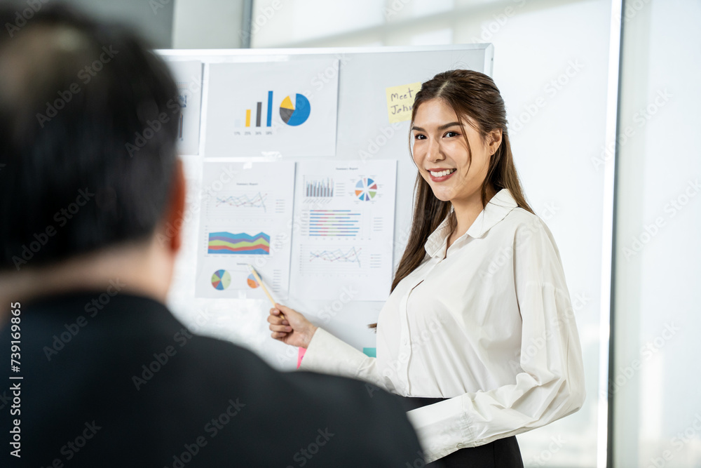 Young asian business woman presenting business chart with team in meeting room. Business meeting concept. Young asian business woman presenting business chart with team in meeting room. Business meeting concept.