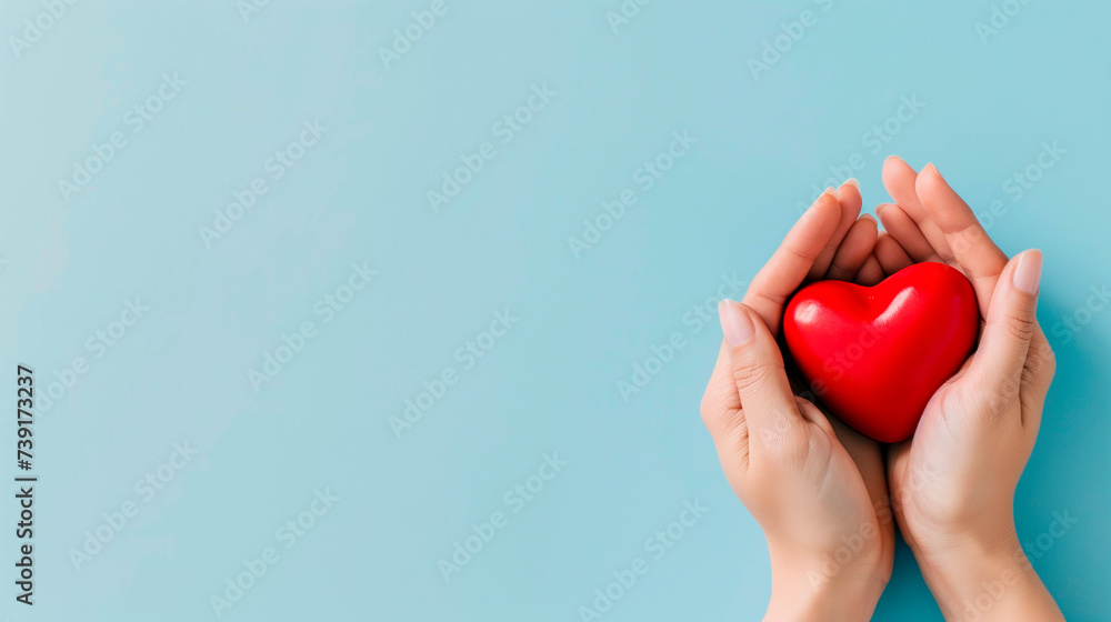 Woman's hands holding red heart on grey background. Valentine's day, health care, world heart day, world health day. Woman's hands holding red heart on grey background. Valentine's day, health care, world heart day, world health day.