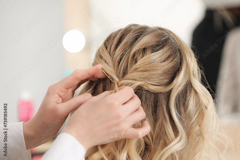 Fototapeta premium Hair styling. Professional hairdresser working with client in salon, closeup
