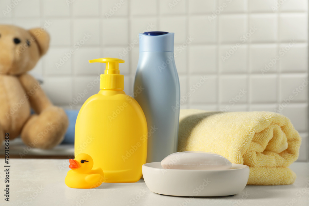 Baby cosmetic products, bath duck and towel on white table Baby cosmetic products, bath duck and towel on white table