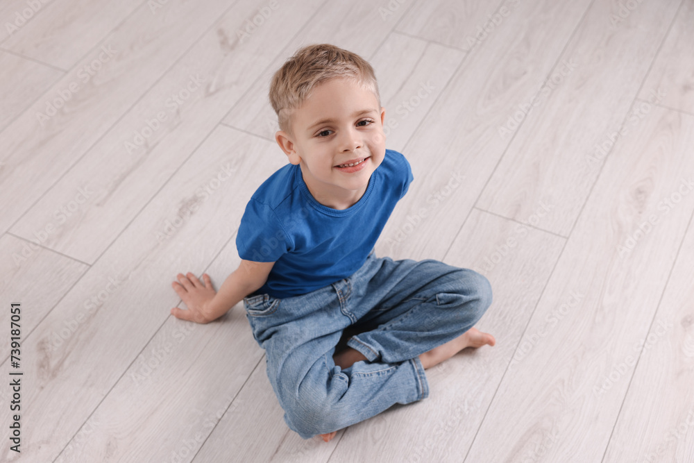 Cute little boy sitting on warm floor indoors. Heating system Cute little boy sitting on warm floor indoors. Heating system